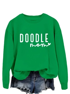 Detail of the green crewneck sweatshirt showing white DOODLE mom graphic and ribbed cuffs