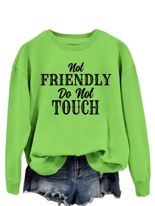 Detail of neon green sweatshirt with black Not Friendly Do Not Touch print and ribbed cuffs