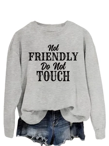 Close-up of the black 'Not FRIENDLY Do Not TOUCH' art text printed on a light grey sweatshirt