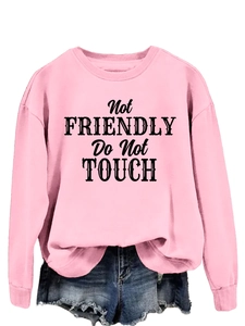 Detailed view of pink crewneck sweatshirt with Not Friendly Do Not Touch slogan print