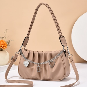 Beige pleated cloud bag with woven handle and rhinestone heart chain detail