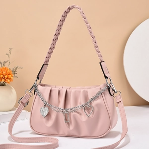 Pink pleated cloud bag with woven handle and heart-shaped silver metal chain pendants