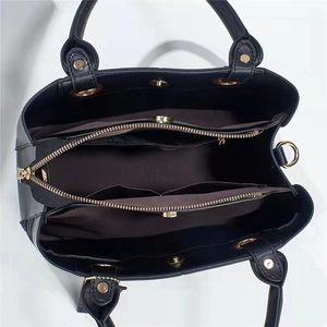 Top view of black multi-compartment handbag showing inner zip pocket and gold hardware