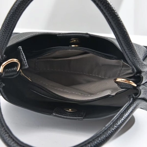 Interior of black pebble leather round handbag with magnetic closure and gold hardware