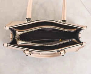 Detailed interior of apricot tote bag featuring golden zipper compartment and dual main pockets