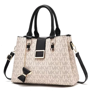 Detail of elegant cream tote bag with MKMT monogram print and black bow charm
