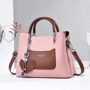 Pink lychee texture crossbody bag with brown handles and FASHION Queen branding