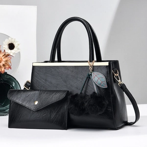 Détail d'un ensemble de sacs à main noirs en cuir texturé avec garnitures dorées