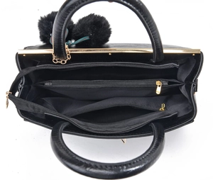 Vue de dessus d'un sac à main noir en cuir grainé avec trois compartiments et zips dorés
