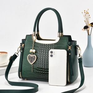 Elegant dark green crocodile pattern handbag with gold hardware and heart pendant