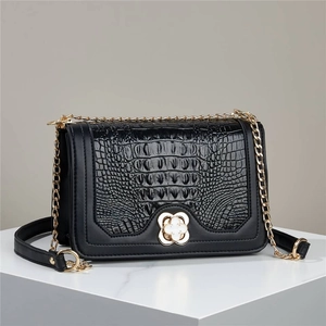 Elegant black crocodile pattern crossbody bag with gold chain and clover buckle detail