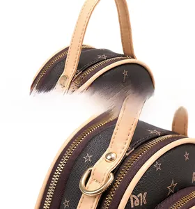 Detail of round handbag with dual gold zippers and MK star pattern printed leather