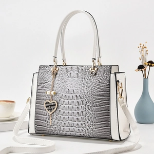 Elegant gray crocodile embossed handbag with white leather accents and gold hardware