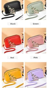 Detail view of multi-compartment crossbody bags with floral embroidery in six colors