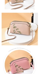 Close-up of floral embroidery on a dual-zipper crossbody bag with golden hardware