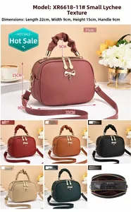 Detail view of small litchi texture bags with bow charms and three inner compartments