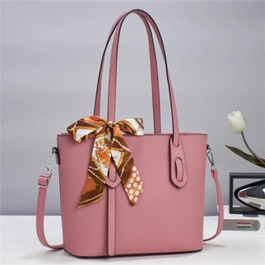 Detail of dusty pink leather tote bag featuring cross-grain texture and decorative silk scarf