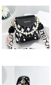 Détail du sac bandoulière à carreaux noir et blanc avec anse perle et logo de mode