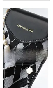 Gros plan sur tissu à carreaux noir et blanc avec perles et logo doré de mode