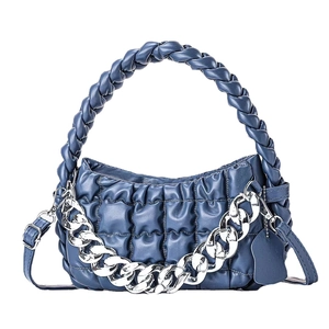 Quilted navy blue handbag with woven handle and bold silver metal chain strap