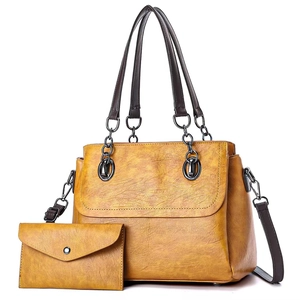 Detail view of ginger yellow tote bag set with matching pouch and chain handles