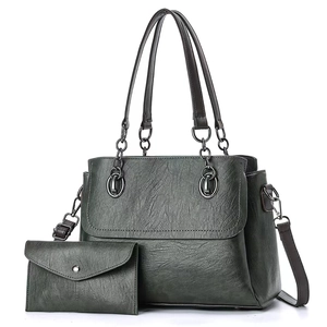 Detailed view of dark green oil wax leather tote bag with matching small clutch wallet set