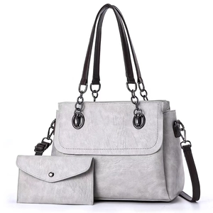 Detail view of grey tote bag set with matching wallet and adjustable brown strap