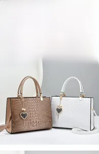 Close-up of brown and white crocodile pattern tote bags with heart charm details