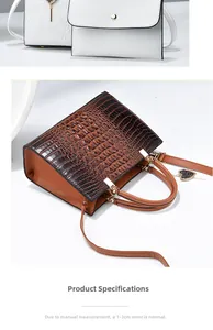 Detail of crocodile embossed leather texture on tote bags with metallic heart charm