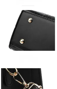 Detail showing gold metal feet on crocodile texture leather and metal strap hooks