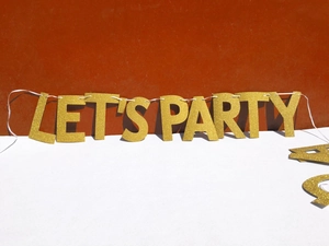 Close-up of gold glitter Let's Party banner with shimmering texture for celebrations