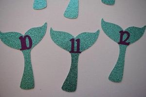 Mermaid tail glitter photo banner with purple numbers 10, 11, 12 for birthday parties
