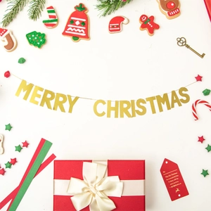 Macro view of gold glitter Merry Christmas banner with pine cones and holiday gifts