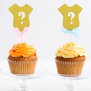 Glittery baby onesie cake toppers with pink and blue bows for gender reveal party
