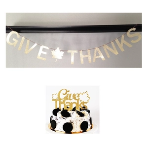 Close-up of golden glitter Give Thanks banner and maple leaf cake topper for Thanksgiving decoration