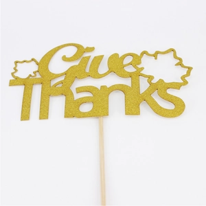 Close-up of glittery gold Give Thanks cake topper with maple leaf for Thanksgiving decor