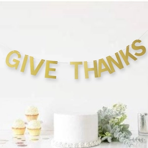 Close-up of gold glitter GIVE THANKS banner for Thanksgiving party decorations