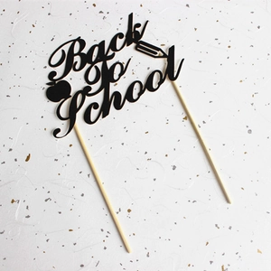 Schwarzer Back to School Tortenstecker mit Apfel und Bleistift auf Glitzerhintergrund