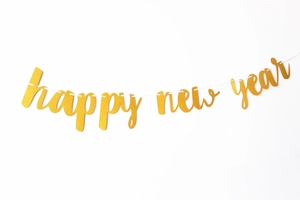 Close-up of golden glitter Happy New Year banner decoration for holiday party backdrop