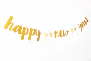 Close-up of golden glitter Happy New Year banner letters with champagne glasses