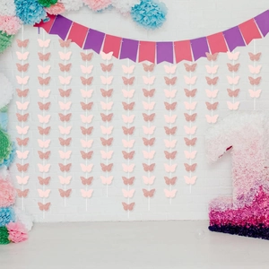 Hanging pink and rose gold glitter butterfly garland for first birthday party background