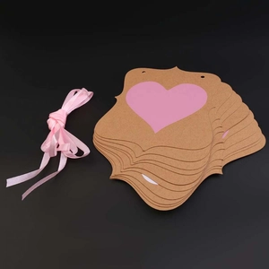 Gros plan d'étiquettes en papier kraft avec cœurs roses et rouleau de ruban assorti