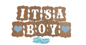Detail of vintage kraft paper 'IT'S A BOY' banner with blue hearts and ribbon for baby shower