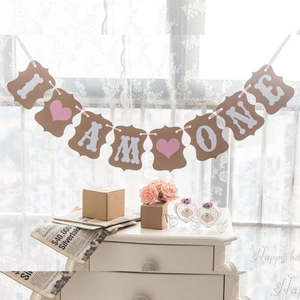 Detail of I AM ONE kraft banner with pink heart and bone for first birthday party decor