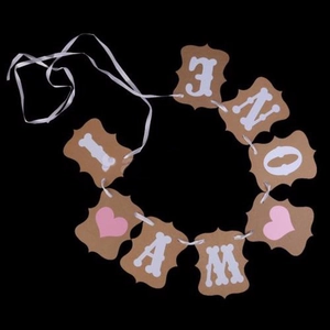 Detail of I AM ONE kraft paper banner with pink heart and bone icons for 1st birthday