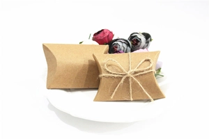 Detail of kraft paper pillow gift box with hemp rope bow for wedding candies and favors