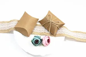 Macro detail of kraft paper pillow boxes with twine bow and dried floral decoration