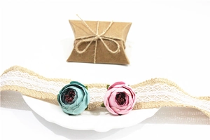 Close-up of decorative fabric flowers and lace ribbon on a kraft paper gift box