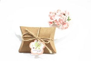 Detail of kraft paper pillow gift box with jute rope and baby carriage tag