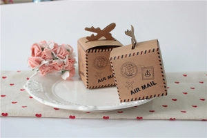 Macro view of kraft paper gift box with airplane handle and vintage air mail stamps
